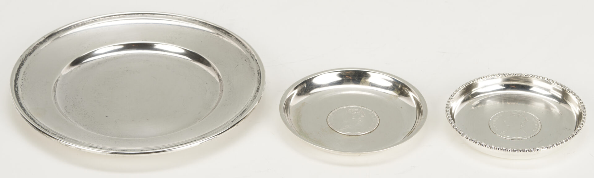 Lot 1015: 6 Sterling Silver Bread Plates & 4 Queen Victoria/King George Rupee Silver Coasters