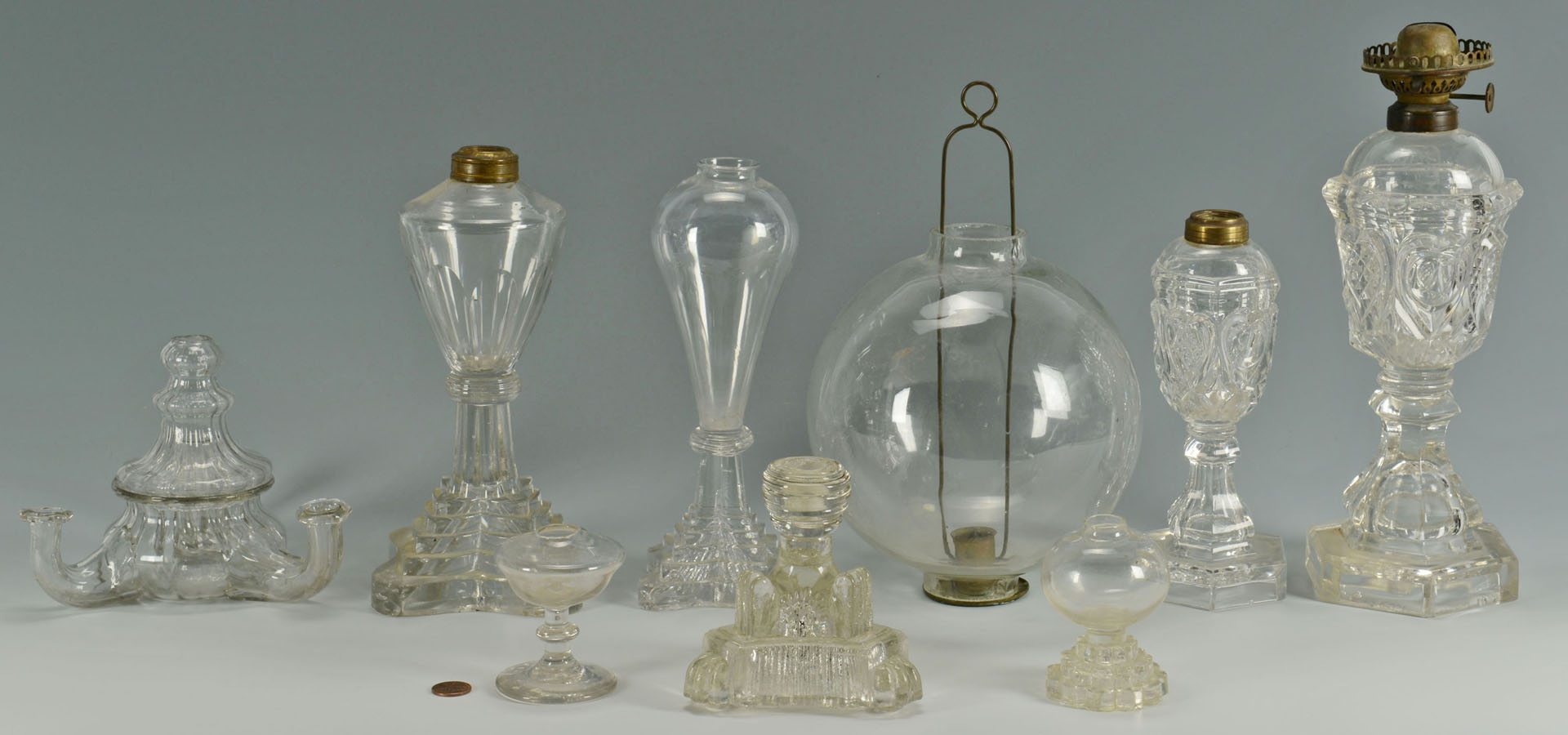 Lot 283: 9 Colorless blown and molded glass oil lamps
