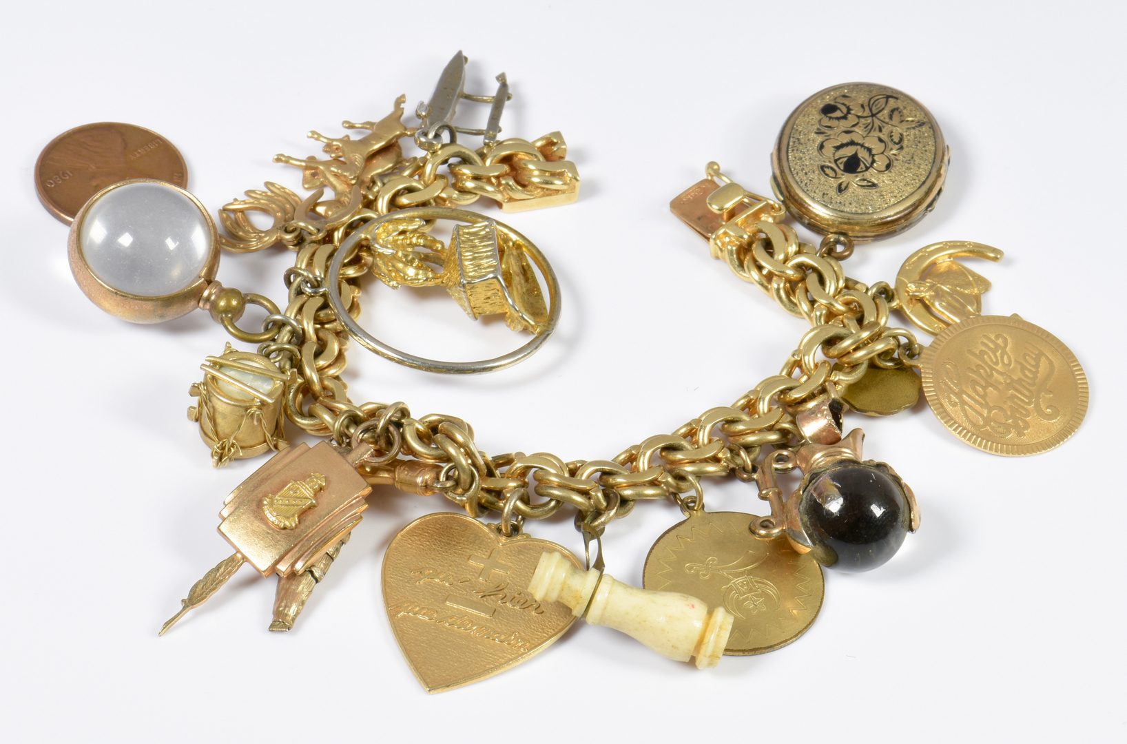 Lot 781: 14K Charm Bracelet, drum, heart, horseshoe, etc.