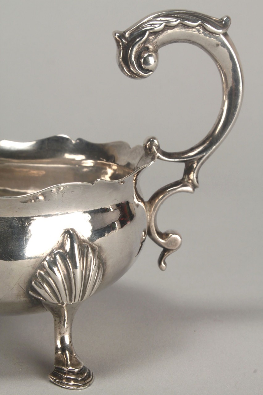 Lot 152: George III Rococo silver sauce boat or cream jug